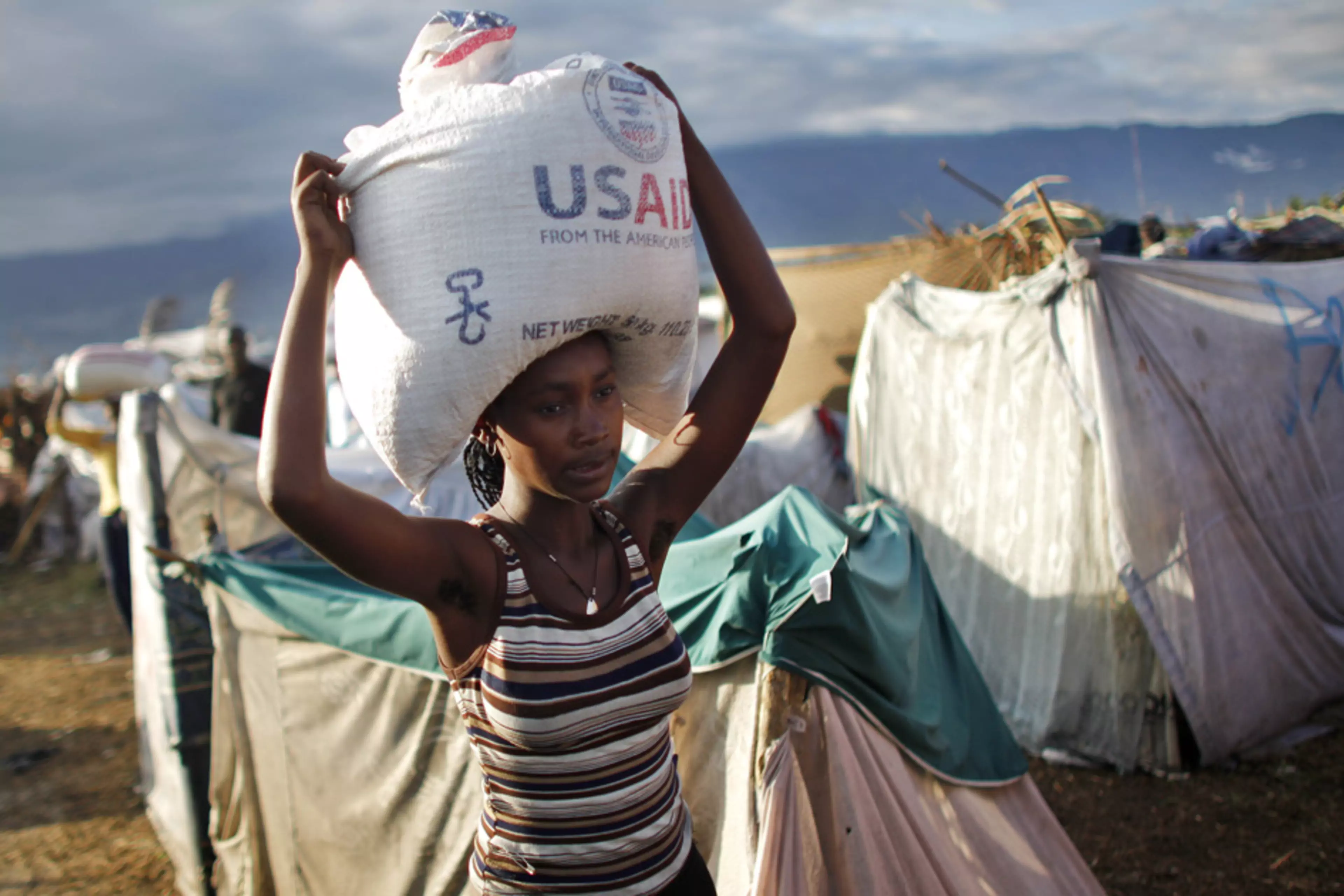 A woman carries a bag of rice distributed by the U.S. Agency for International Development (USAID) in Port-au-Prince, Haiti. 