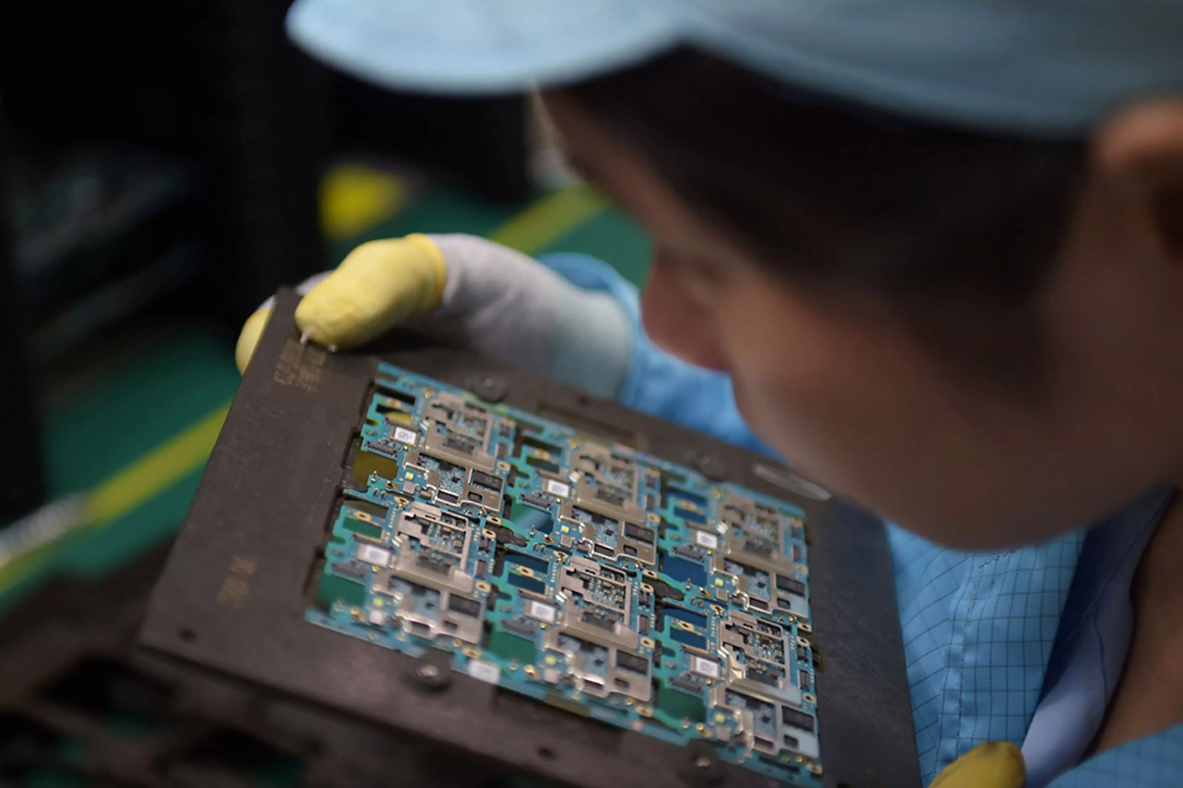 A worker handles smartphone chip components at a factory in Dongguan, China.