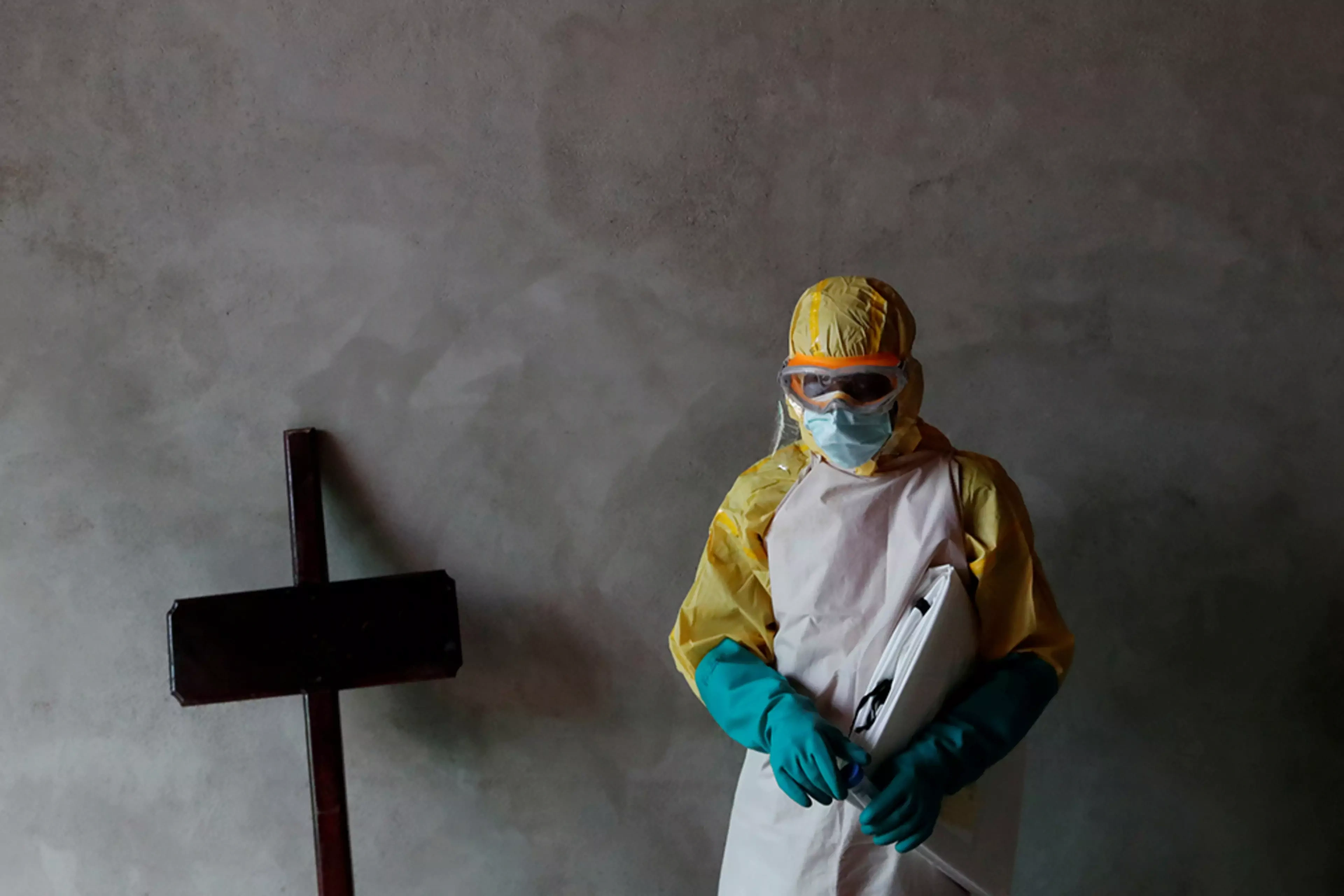 A health worker stands during the funeral of a suspected Ebola victim in the Congolese city of Beni.