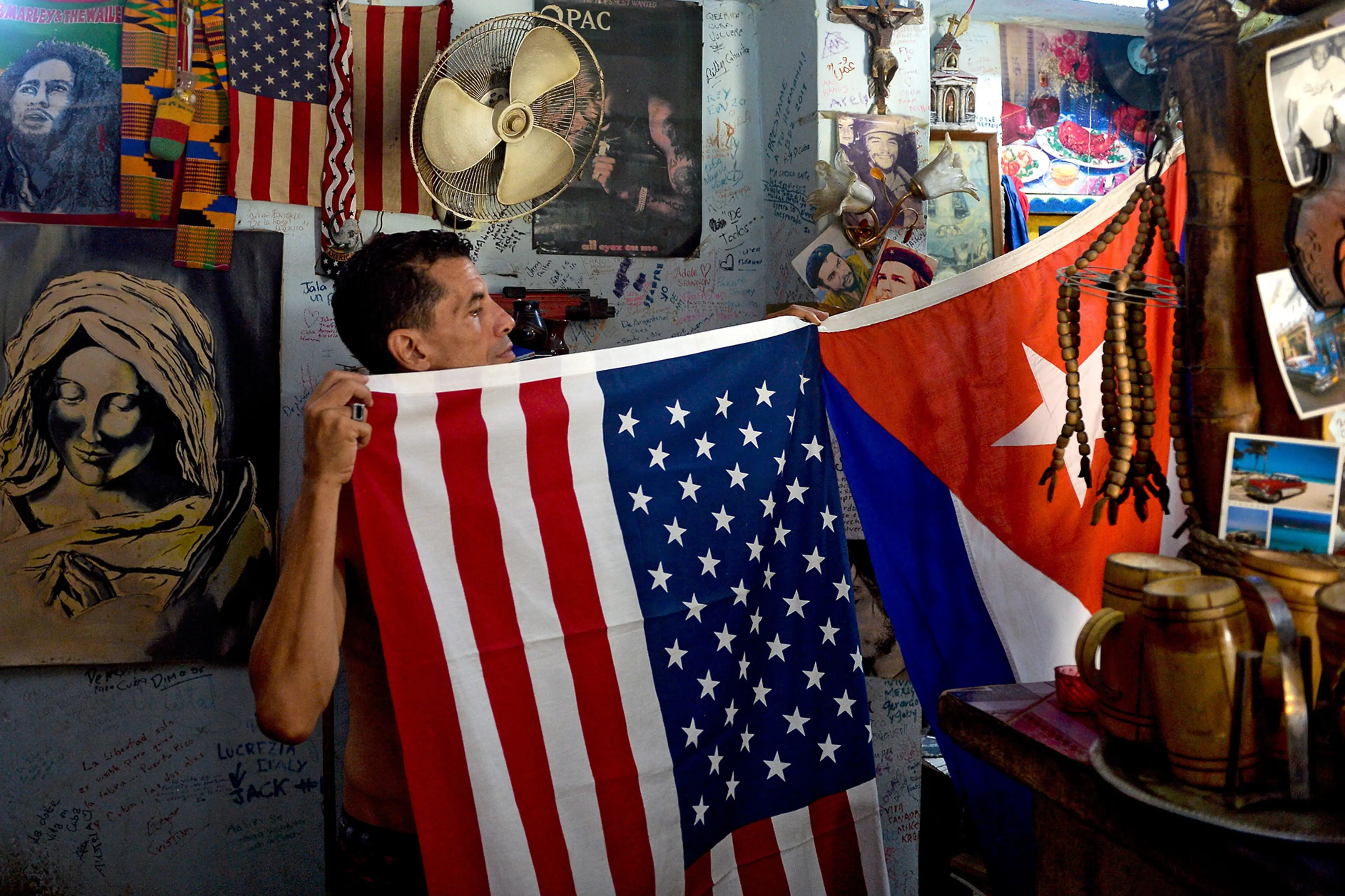 A man shows U.S. and Cuban flags at his house in Havana.