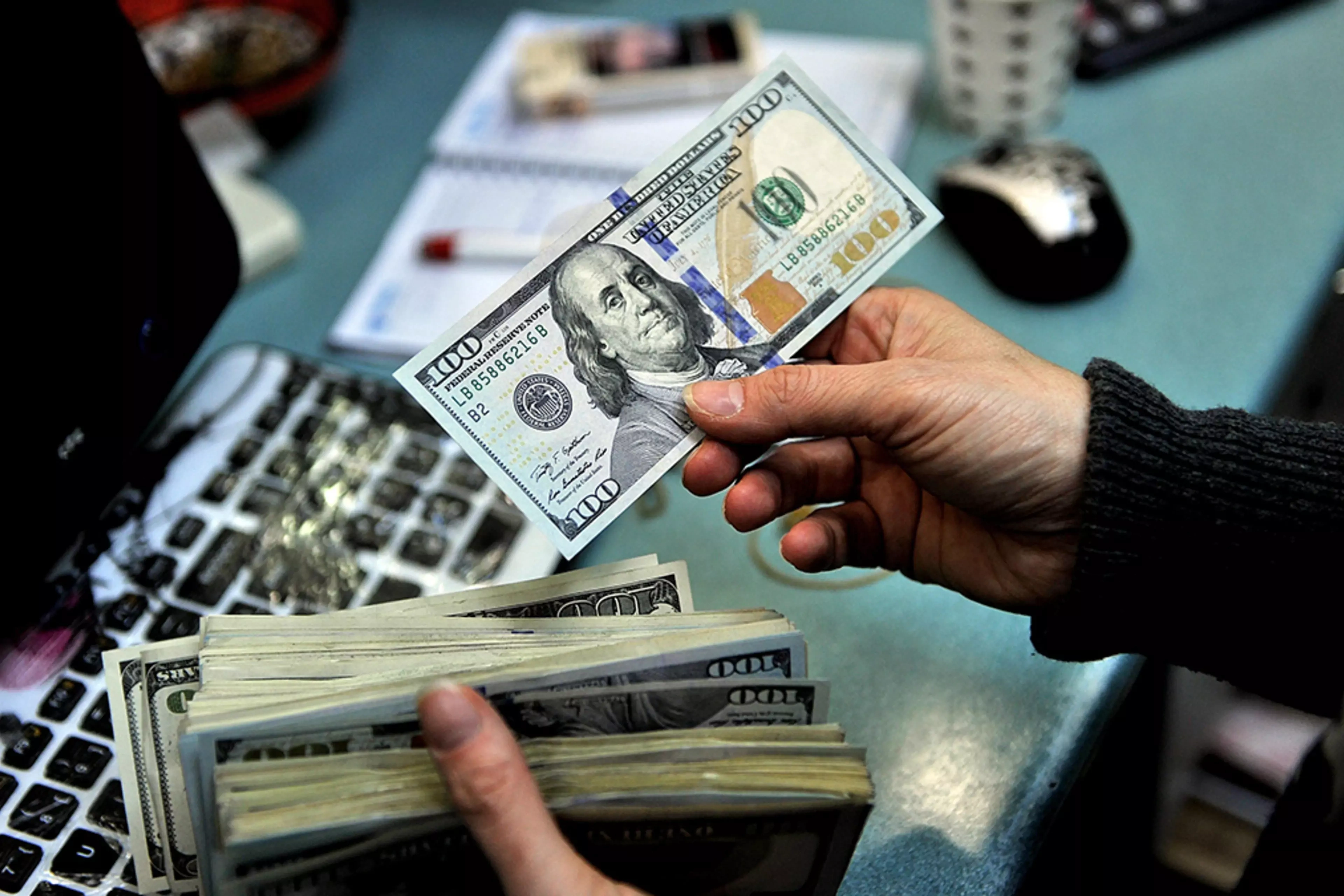 An exchange office clerk counts U.S. dollars in Istanbul, Turkey.