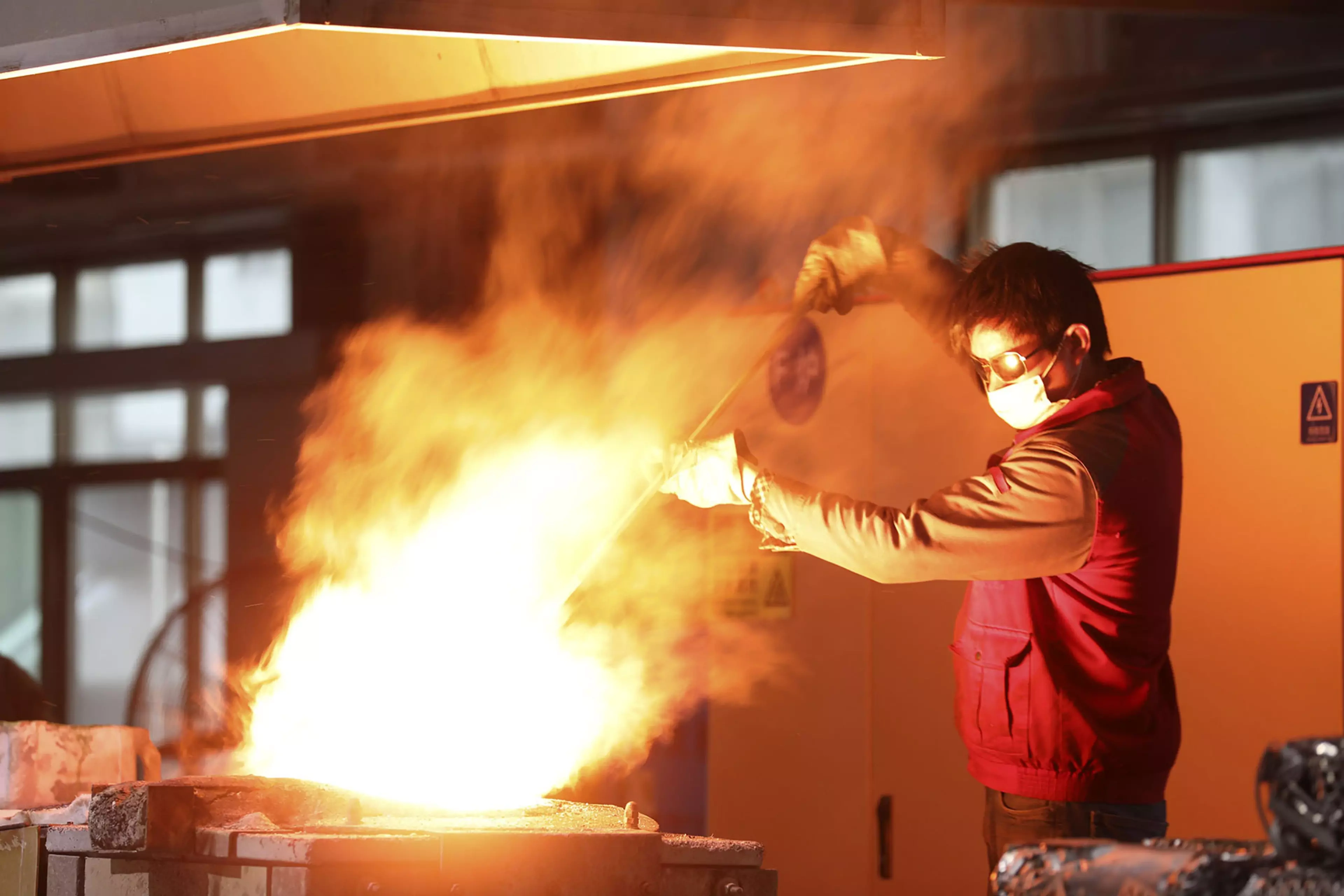 A Chinese worker rushes to produce stainless steel products for export.