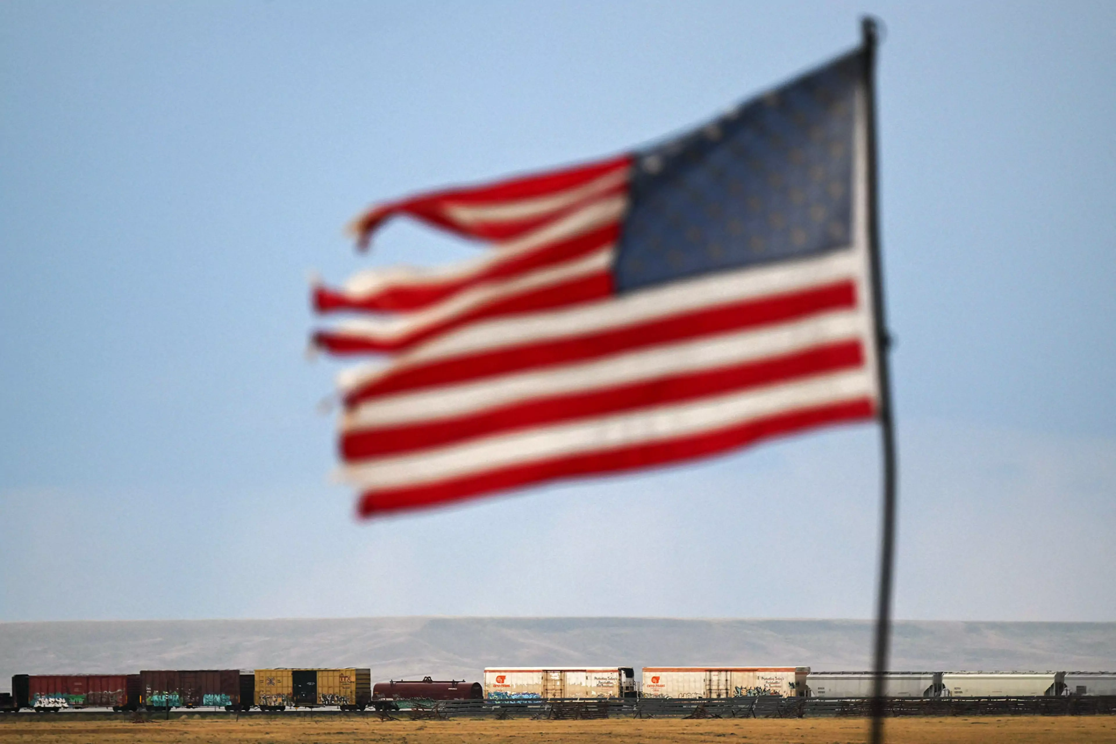 A U.S. flag waves above a freight train in Bosler, Wyoming.