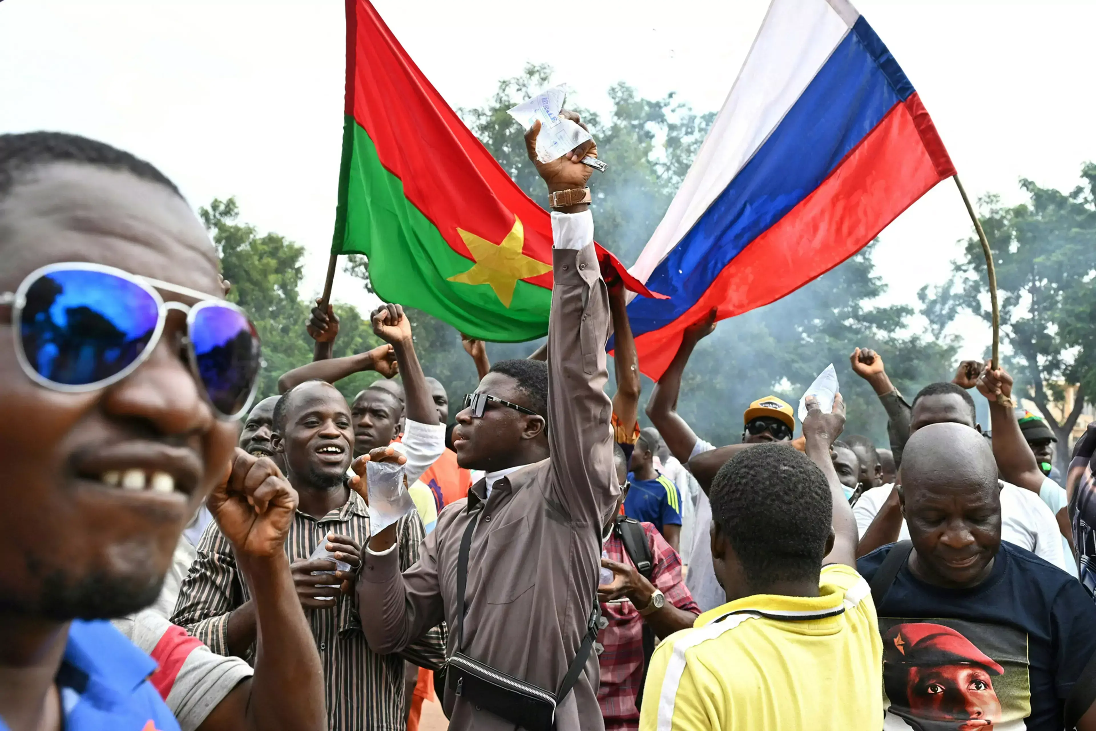 Demonstrators lift Burkinabè and Russian flags after Burkina Faso’s second 2022 coup.