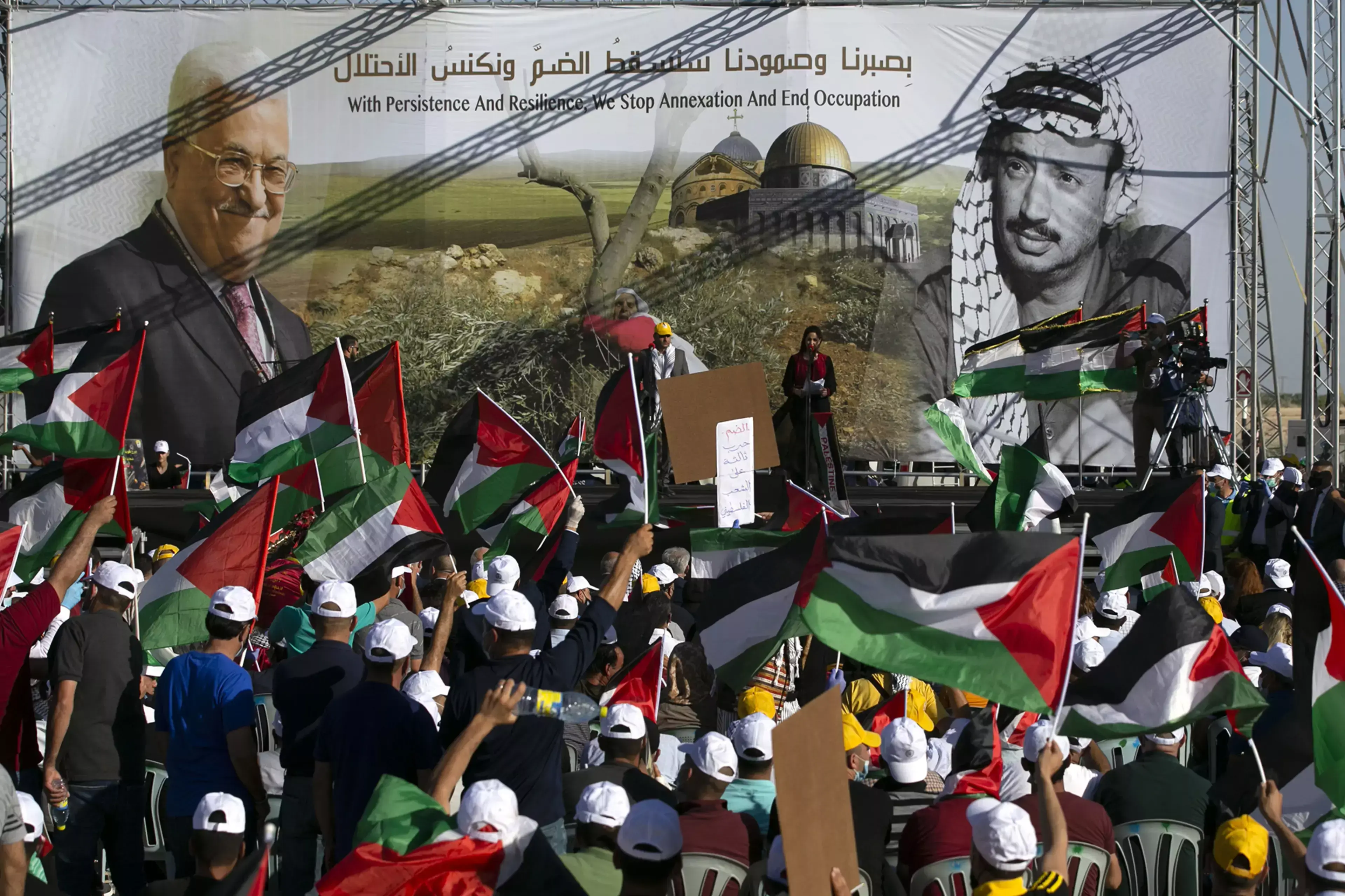 Palestinians rally beneath images of President Mahmoud Abbas and his predecessor, Yasser Arafat.