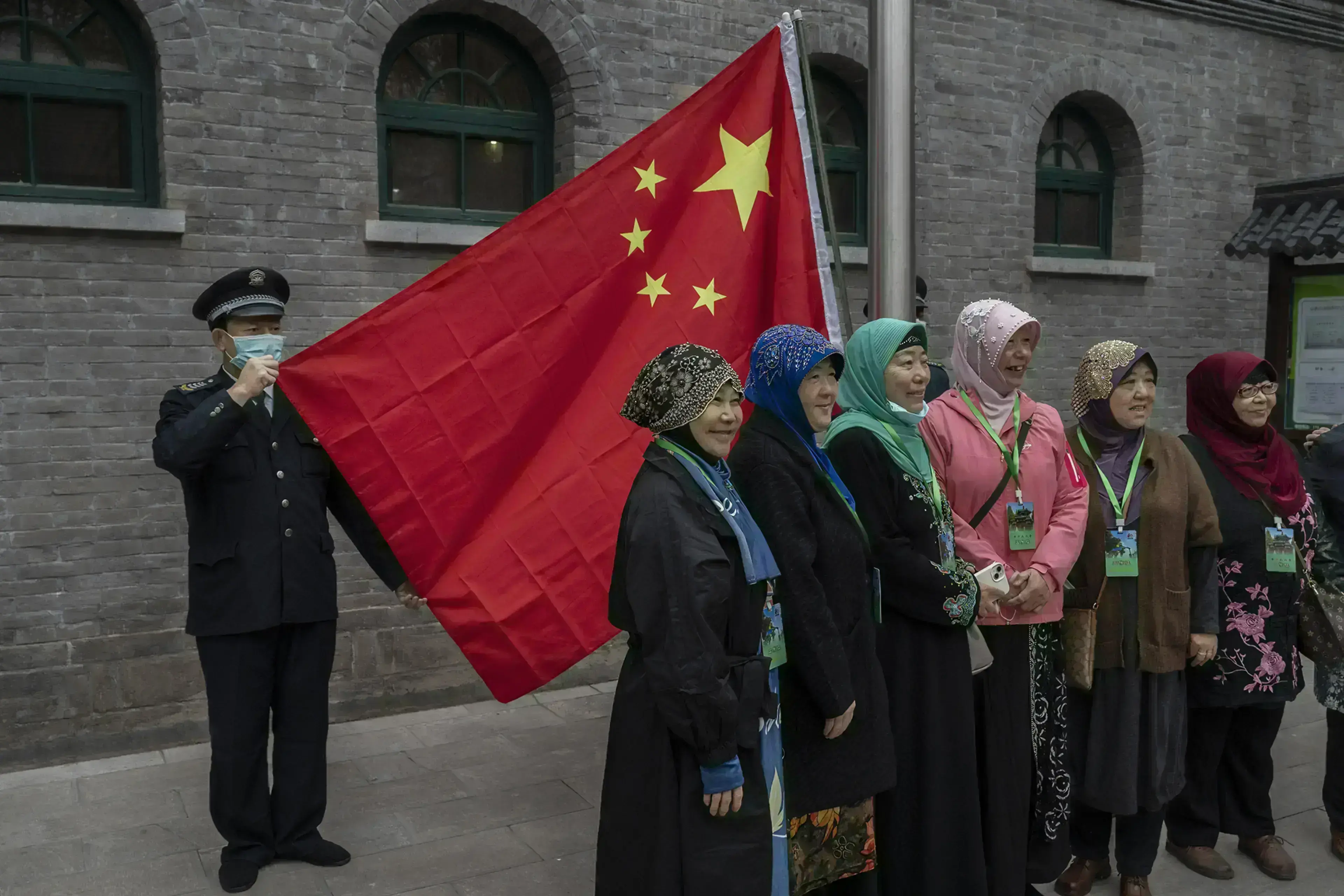 Hui Muslim women stand in front of China’s flag at a mosque in Beijing.