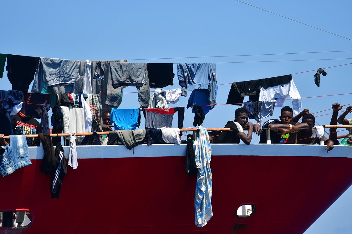 Migrants look out from a tourist ship at Hurd's Bank on June 2, 2020.