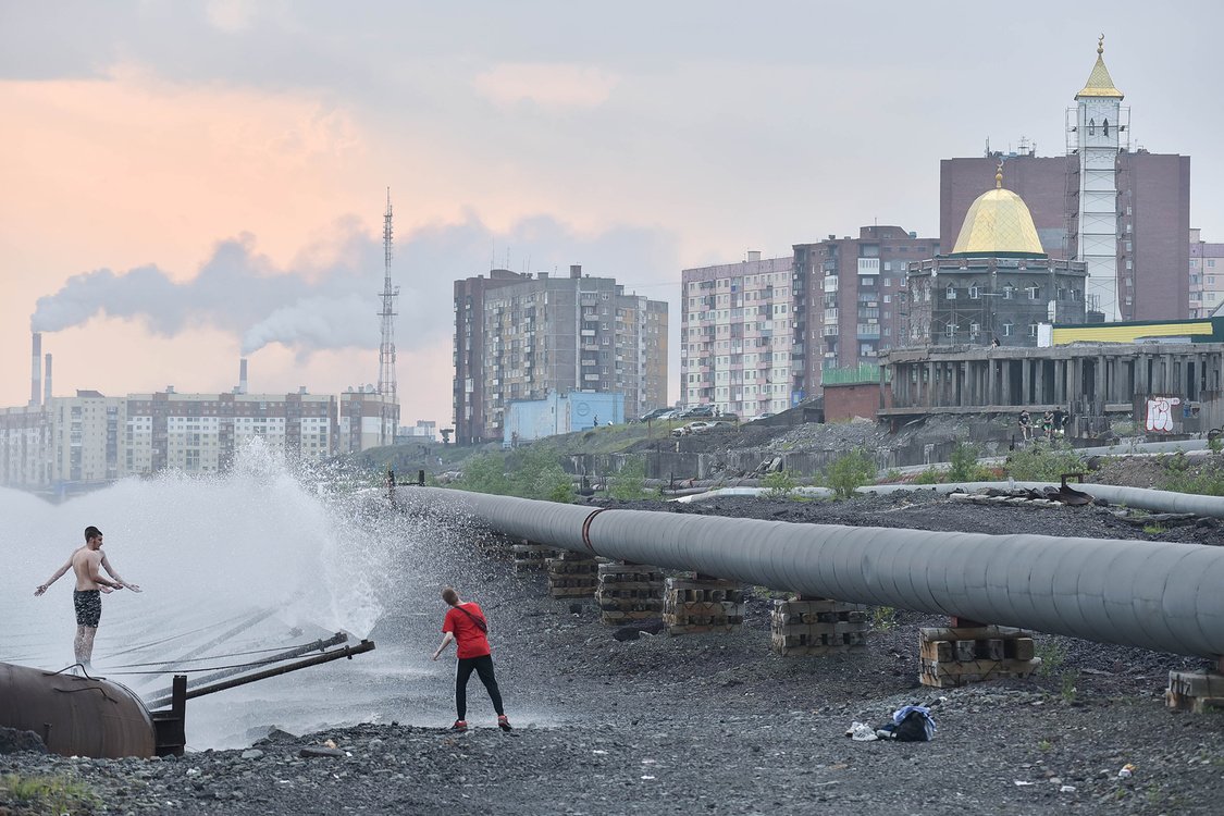 People are seen by fountain sprays on Lake Dolgoye in the Russian city of Norilsk in northern Siberia