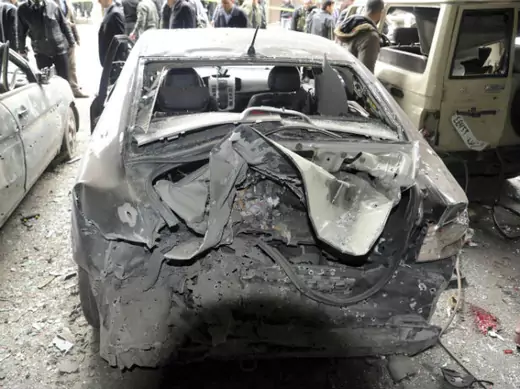 People gather around damaged cars at the site of an explosion in the Maidan district of Damascus January 6, 2012, in this handout photograph released by Syria's national news agency SANA. A suicide bomber killed several people and wounded dozens in central Damascus on Friday, Syrian state television said.