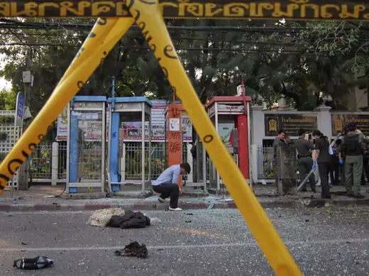 Police and forensic experts investigate the site where a man was injured when a bomb he was carrying exploded, in central Bangkok February 14, 2012.