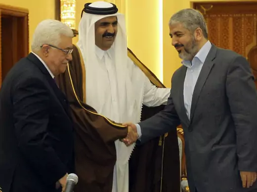 Palestinian President Mahmoud Abbas, Qatar's Emir Sheikh Hamad bin Khalifa al-Thani and Hamas leader Khaled Meshaal talk before an agreement signing ceremony in Doha.