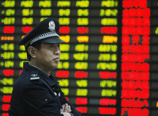 A security guard stands in front of an electrical board displaying stock information at a brokerage house in Huaibei