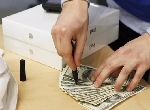 An Apple store employee checks cash for counterfeit bills after a customer purchased a pair of Apple iPad 2 tablets (Lucas Jackson/Courtesy Reuters).