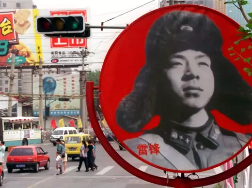 A portrait of Chinese national folk-hero, Lei Feng looks out over a busy intersection in a central Beijing shopping district in June of 1998.