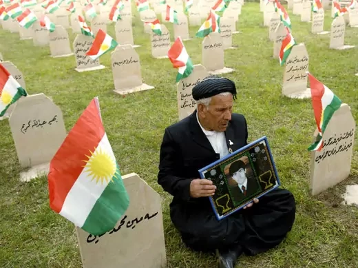 A resident holds a picture of his son at a cemetery for Kurdish poison gas victims in the town of Halabja on March 16, 2010 (Jamal Penjweny/Courtesy Reuters).