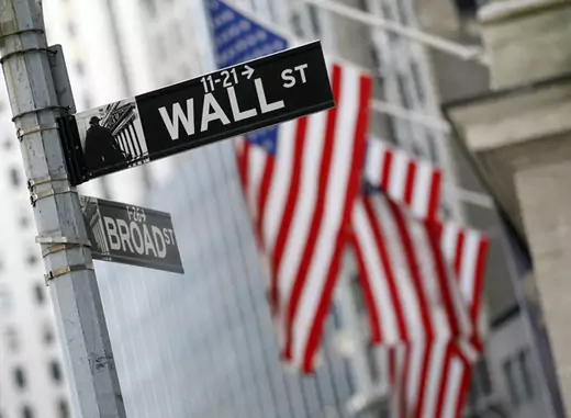 A Wall St. sign is seen outside the New York Stock Exchange.