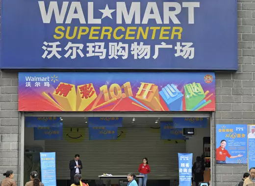 Employees stand in front of the gate to a Wal-Mart Supercenter in Chongqing municipality, China. (Stringer/Courtesy Reuters) 