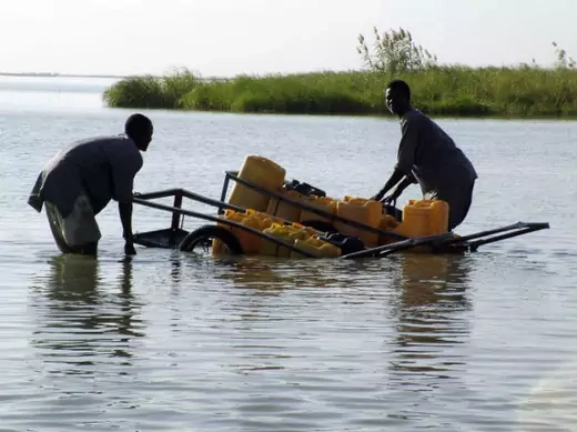 Chadian men collect water with plastic canisters loaded on a hand cart in Lake Chad, on the island of Kouirom, January 27, 2007.