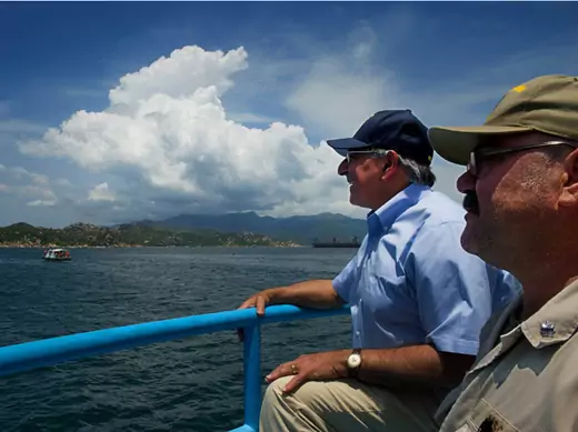 U.S. defense secretary Leon Panetta sits next to USNS Richard E. Byrd chief mate Fred Cullen as they take a water taxi to the ship in Cam Ranh Bay