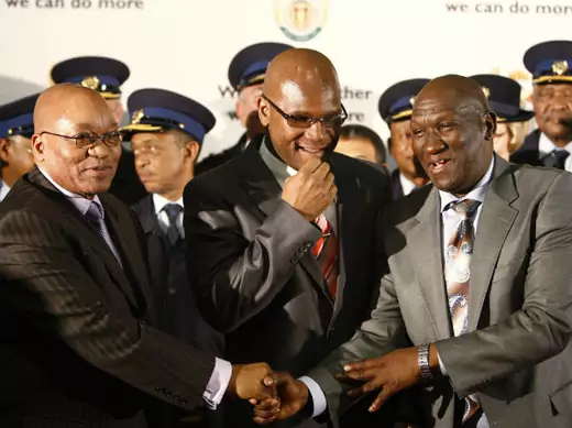 Newly appointed South African national police commissioner, Bheki Cele (R), is congratulated by South African President Jacob Zuma as Safety and Security Minister Nathi Mthethwa (C) looks on at the end of the news conference in Pretoria, July 29, 2009.