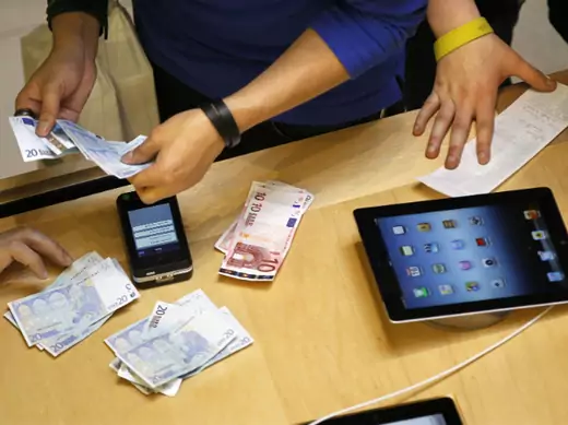 A cashier counts euro banknotes as a customer purchases an Apple iPad in Paris on March 16, 2012 (Charles Platiau/Courtesy Reuters). 