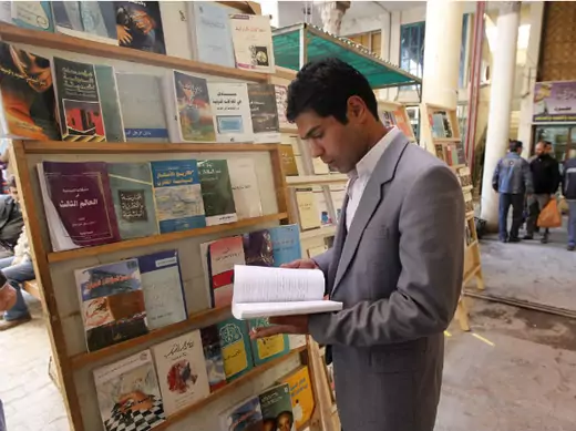 A man reads a book at Mutanabi Street in Baghdad