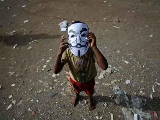 A child wears a paper mask depicting Guy Fawkes during a protest by Anonymous India against laws they say gives the government control over censorship of Internet usage in Mumbai, June 9, 2012. 