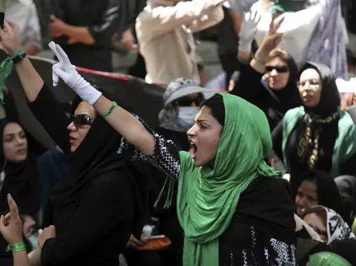 Iranian protesters flash victory signs during Friday prayers at a university in Tehran