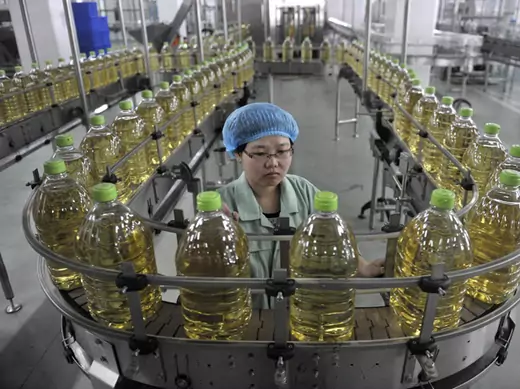 An employee works at the production line of an edible oil company in Sanhe, Hebei April 12, 2011.
