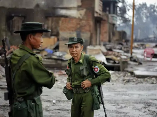 Soldiers patrol through a neighbourhood that was burnt during this summer's violence in Sittwe, Rakhine State.