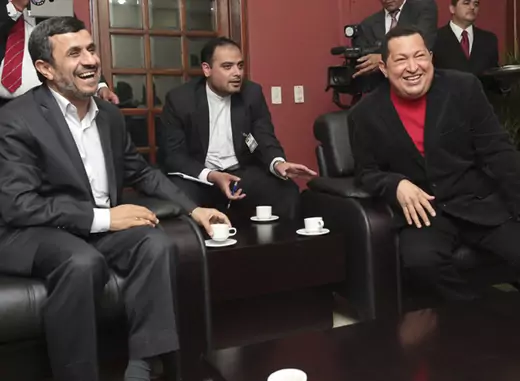 Venezuela's President Hugo Chavez and Iran's President Mahmoud Ahmadinejad laugh as they watch TV during a visit at Miraflores Palace in Caracas