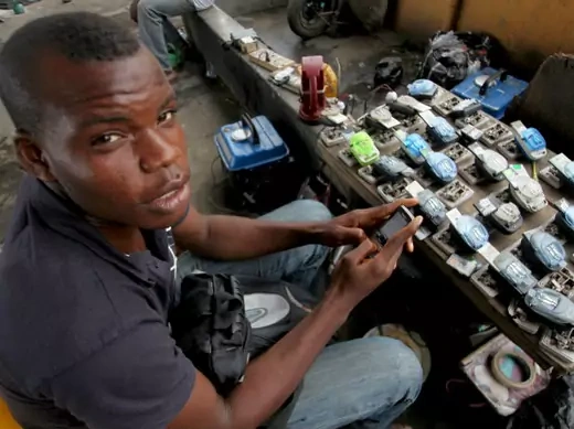 Jamil Idriss charges 50 naira ($0.33) to recharge phone batteries using rows of three-pin sockets nailed to a plank of wood and plugged into a diesel generator in the Obalende District of Lagos May 20, 2010. 