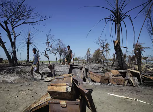 People collect pieces of metal from the rubble of a neighborhood in Pauktaw township in Rakhine State, Myanmar that was burned in recent violence October 27, 2012.