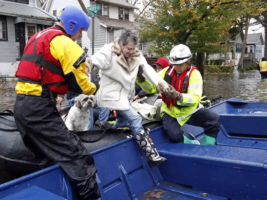 Emergency personnel help a resident onto a boat after rescuing her from flood waters brought on by Hurricane Sandy in Little Ferry, New Jersey on October 30, 2012 (Adam Hunger/Courtesy Reuters).
