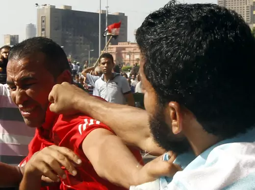 A member of the Muslim Brotherhood and supporter of Egyptian president Mohammed Morsi punches an anti-Brotherhood protester at Tahrir Square on October 12, 2012 (Chany/Courtesy Reuters).