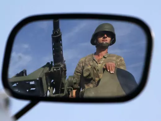 A Turkish soldier is reflected on a mirror as he stands guard on the Turkish-Syrian border near the Akcakale border crossing on October 4, 2012 (Sezer/Courtesy Reuters).