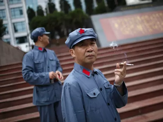 A visitor dressed as a Red Army soldier smokes as he poses for a picture in Jinggangshan, Jiangxi province on September 20, 2012. (Carlos Barria / Courtesy Reuters)