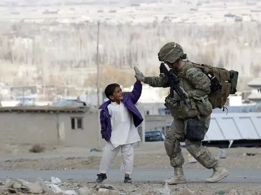 A U.S. Army soldier high-fives with an Afghan boy during a patrol in eastern Afghanistan (Umit Bektas/ Courtesy Reuters). 