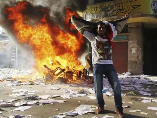 A protester cheers as items ransacked from an office of the Muslim Brotherhood's Freedom and Justice Party burn in Alexandria on November 23, 2012 (Stringer/Courtesy Reuters).