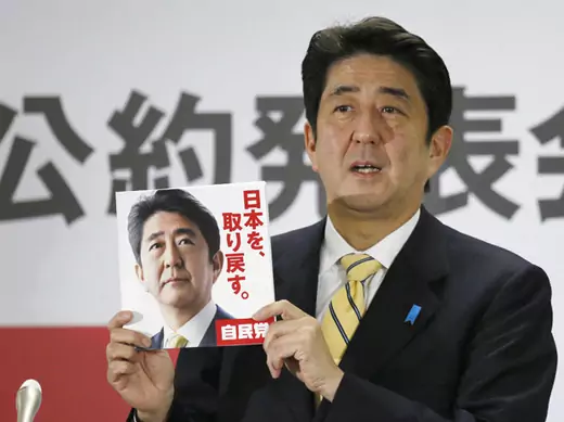 Liberal Democratic Party (LDP) leader Shinzo Abe shows a leaflet from the party's campaign during a news conference in Tokyo (Kyodo/ Courtesy Reuters).