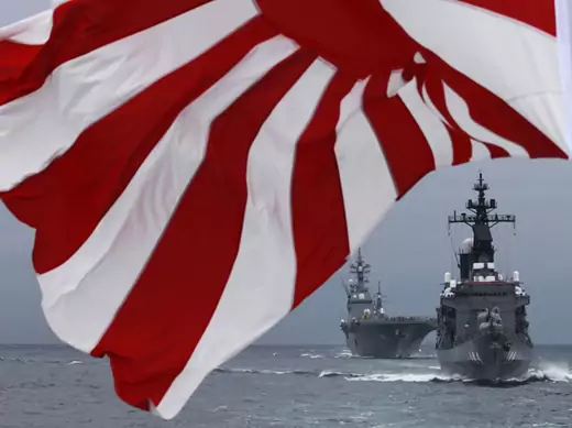 Japanese Maritime Self-Defense Force (MSDF) destroyer Kurama (R) leads destroyer Hyuga as a Japanese naval flag flutters during a naval fleet review at Sagami Bay, off Yokosuka, south of Tokyo October 14, 2012