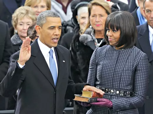 U.S. President Barack Obama recites his oath of office as first lady Michelle Obama looks on during swearing-in ceremonies on the West front of the U.S Capitol in Washington, DC, on January 21, 2013.