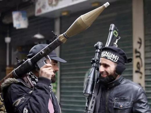 Syrian rebels talk as they carry their weapons before heading to the front line in Aleppo on January 9, 2013 (Karam/Courtesy Reuters).