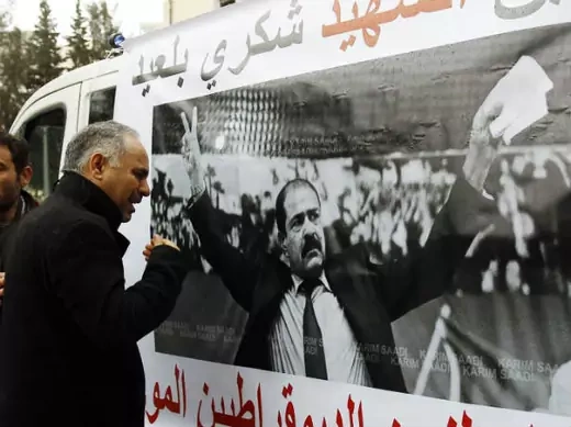 A man cries next to a poster with an image of Chokri Belaid, a prominent Tunisian opposition politician who was shot dead, in Tunis February 7, 2013 (Souissi/Courtesy Reuters).