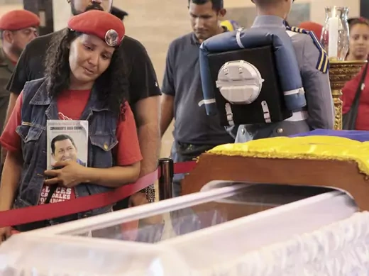A supporter of the late Venezuelan president Hugo Chavez views his coffin in Caracas (Miraflores Palace Handout/Courtesy Reuters).