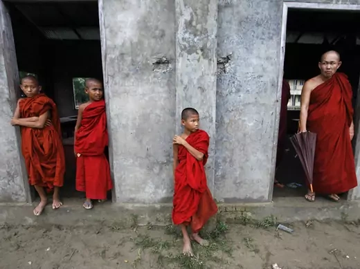Buddhist novice monks look from a monastery during fighting between Buddhist Rakhine and Muslim Rohingya communities in Rakhine State.