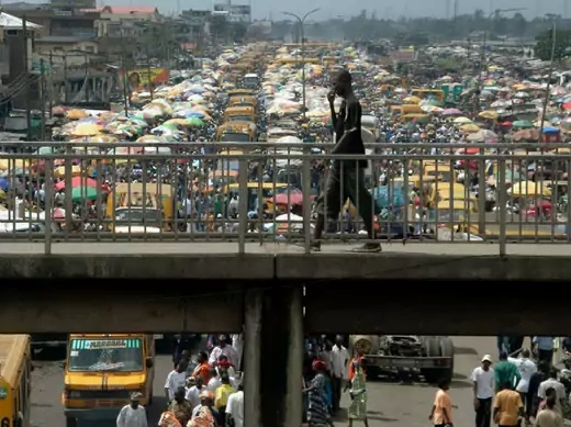 A man walks on a pedestrian bridge overlooking traffic in Lagos, Nigeria, September 18, 2006.