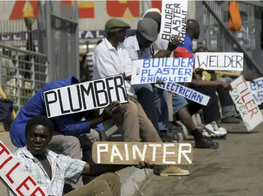 Men hold placards offering temporal employment services in Glenvista, south of Johannesburg, October 7, 2010.