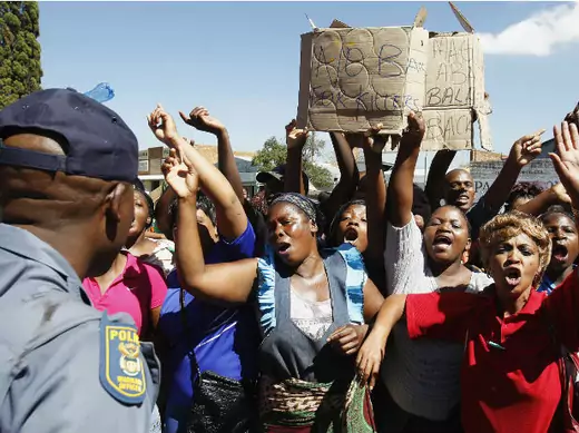 Protesters chant slogans in front of a policeman outside the Benoni courtroom, in east Johannesburg, March 4, 2013.