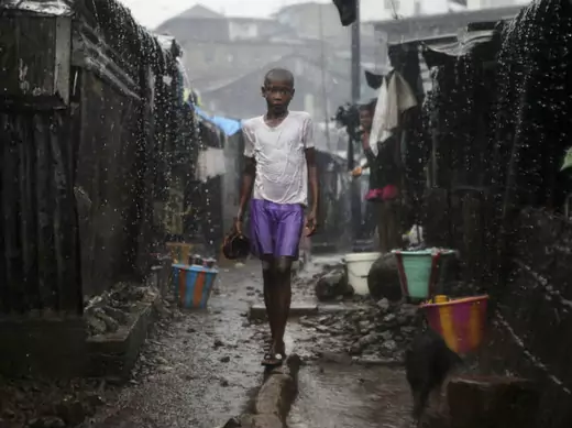 A child stands in pouring rain in the slum of Susan's Bay in Sierra Leone's capital Freetown, August 22, 2012.
